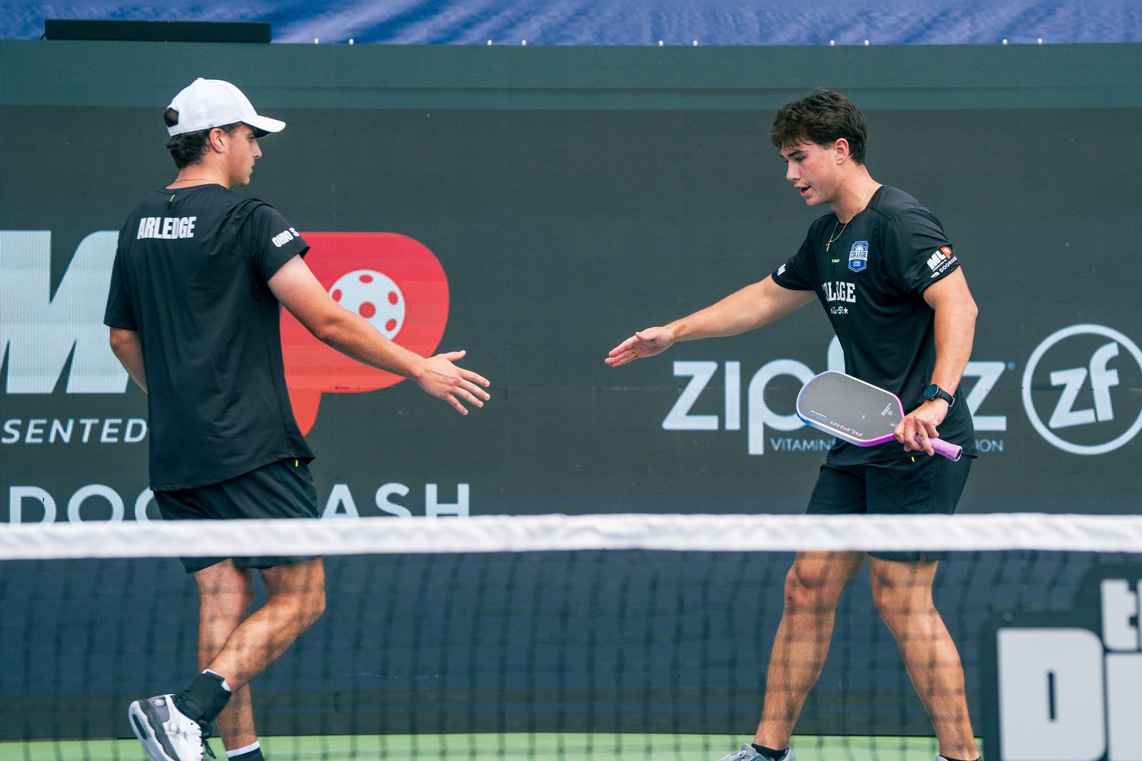 Ryan Morneau and his doubles partner shaking hands at the net